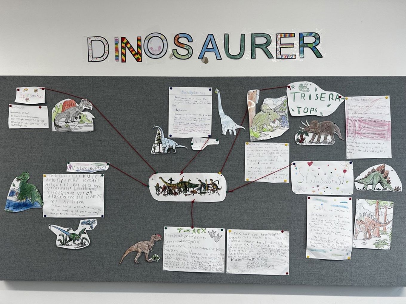 En vegg med ulike tegninger og papirer En vegg med ulike tegninger og papirer