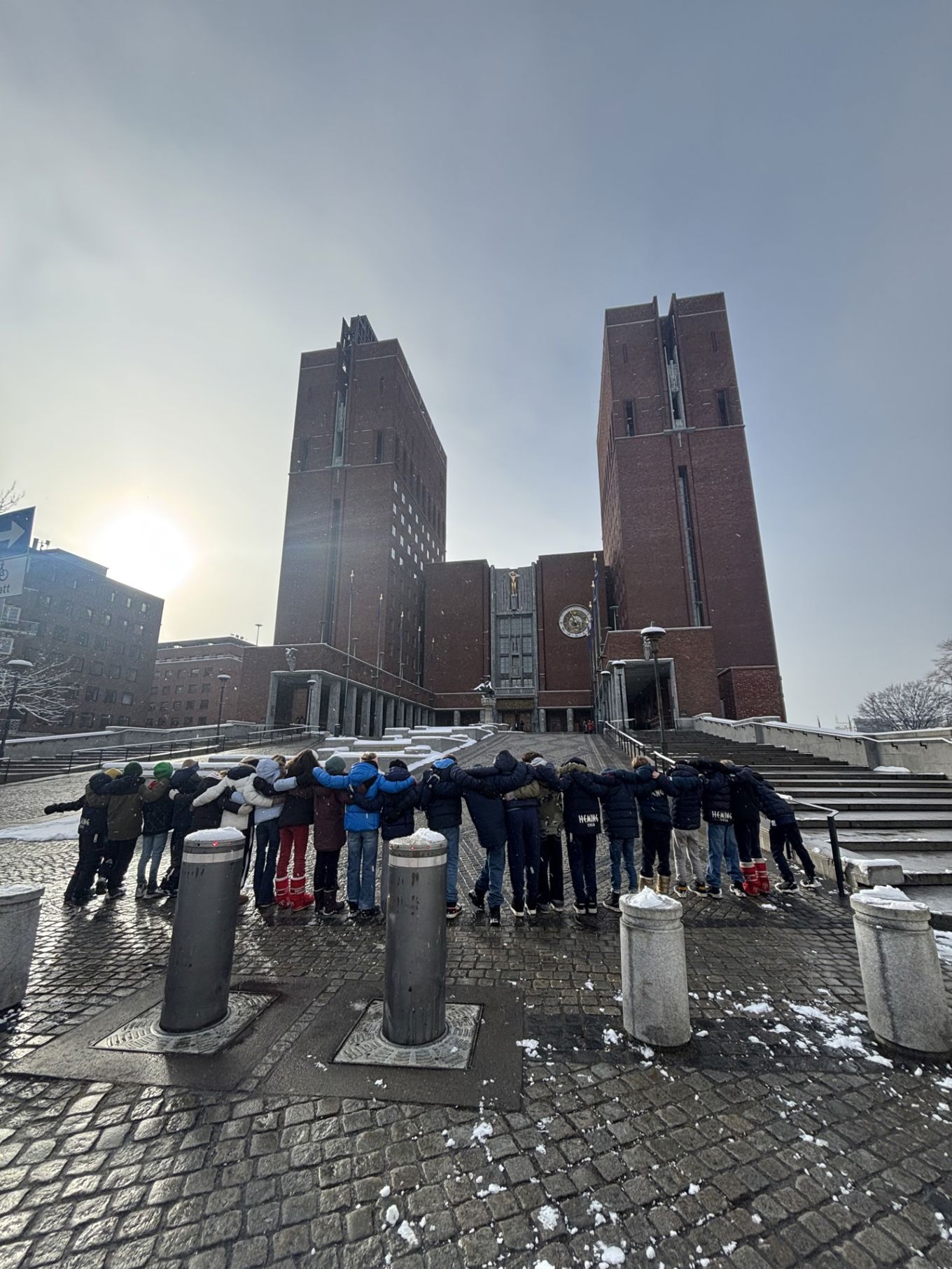 en gruppe mennesker som står på en steingangvei med bygninger i bakgrunnen en gruppe mennesker som står på en steingangvei med bygninger i bakgrunnen