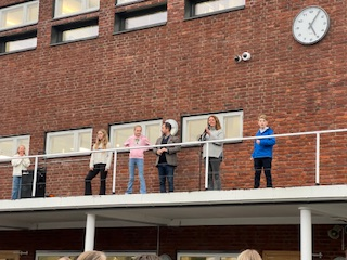 Skolen en gruppe mennesker som står på en balkong