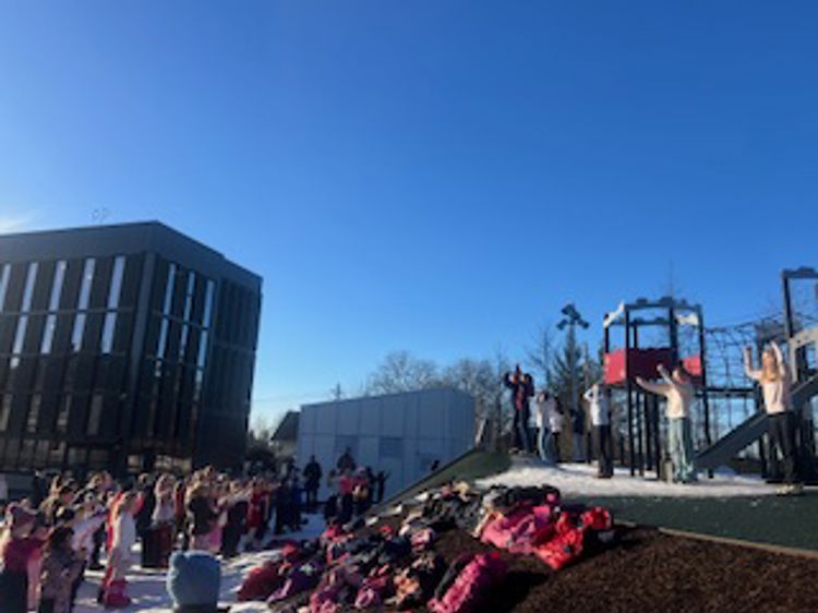 Skolen danser fellesdans og jenter fra 7. klasse viser stegene.