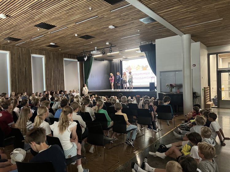 Foto: Grete Berset Flere klasser som sittter og ser på 4. trinn på scenen.