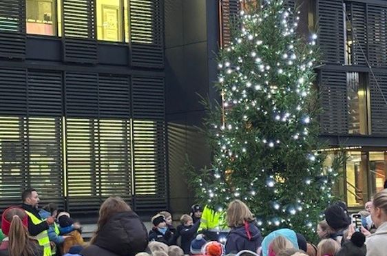 Foto: Slemdal skole En gruppe mennesker som sitter foran et juletre