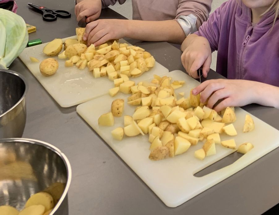 Foto: AKS en person som kutter opp mat