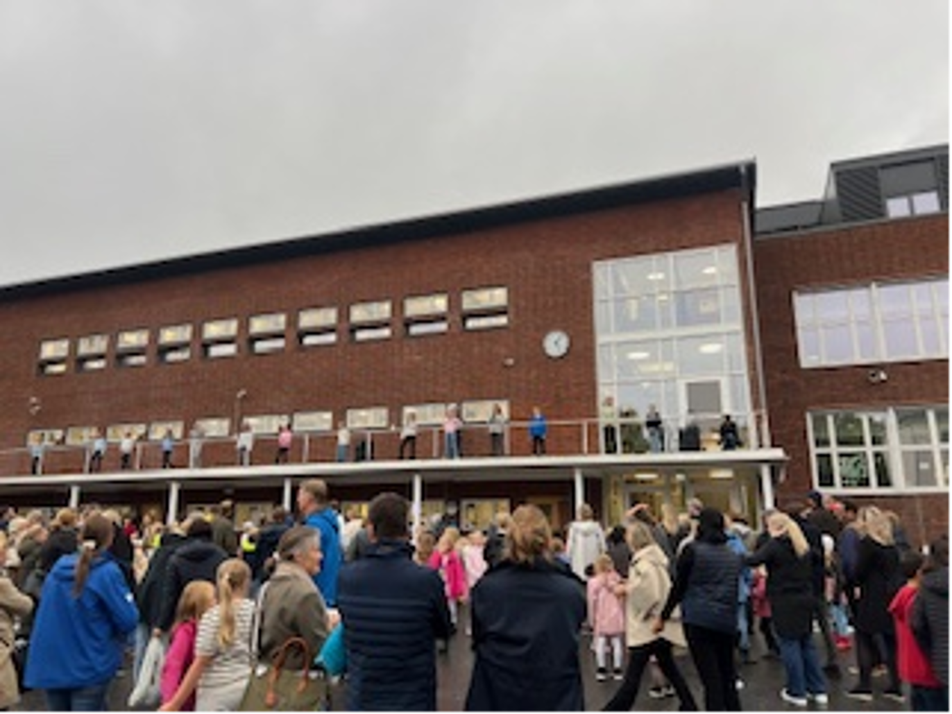 Foto: Skolen en gruppe mennesker utenfor en bygning
