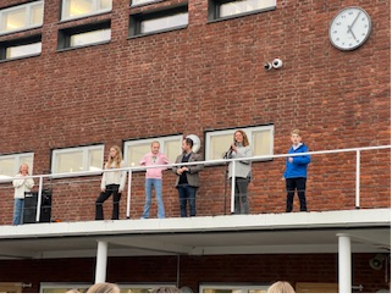Foto: Skolen en gruppe mennesker som står på en balkong